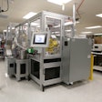 The front of the AFTCATS robotic bottling system shows the main touchscreen display, with the pick-and-place loading robot shown in the window.