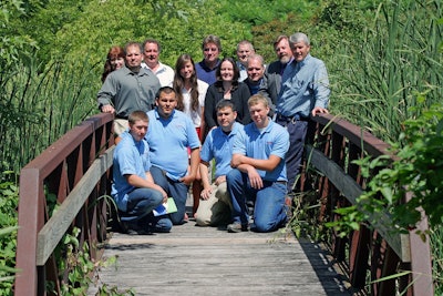 ‘BRIDGING’ THE SKILLS GAP. Representatives from the three organizations involved in developing the apprenticeship program join the first four apprentices on the bridge that connects Bosch’s New Richmond, WI, facility grounds and the Wisconsin Indianhead Technical College campus. Back row L-R: Nancy Cerritos (WITC); Kevin Lipsky (WITC); Pres Lawhon (Bosch); Olaf Wick (WITC); Randy Deli (WITC). Middle row L-R: Travis Ludvigson, (State of Wisconsin Bureau of Apprenticeship Standards); Alexandra Nungesser (Bosch); Ashley Bauman (Bosch); Chris Jehle (Bosch); Mark Hanson (Bosch). Front row L-R: Brant Couch, Philip Taylor, Paul Petty, and Josh Marquand.