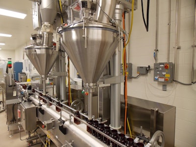 Bottles on the conveyor line pass underneath the two Spee-Dee fillers. After the bottles are filled they are sealed and prepped for shipping.