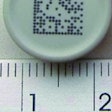 VIAL STOPPER. This image shows a continuous ink-jet code on a vial stopper.