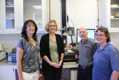 From left to right, Gina Maroney, Corinne McGill, Dale Marcuccilli, and Laure Larkin around the Instron machine set up for a lid tensile test. (Missing: Binal Shah).