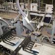 Once pouches are cut into individual units, a pick-and-place device puts each pouch on a pedestal checkweigher.