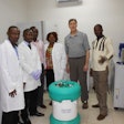 Geoffrey Glauser poses with officials from the College of Medical and Health Sciences and an Arktek container.