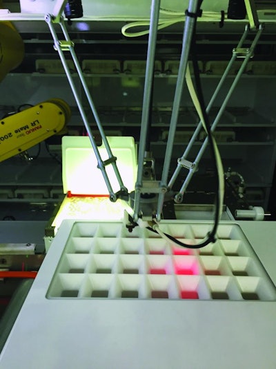 During tray filling, pills are dispensed by a robot through a grid that uses laser beams to verify correct pill placement.