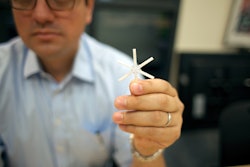 The star-shaped drug delivery device, held here by Giovanni Traverso, a Koch Institute research affiliate, can be folded inward and encased in a smooth capsule. Once ingested, the device delivers a full drug payload gradually over weeks or even months. Photo Credit: Melanie Gonick