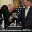 Trump trying to break a medicine vial with a vise with Corning CEO, Wendell Weeks / Image: UPI