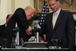 Trump trying to break a medicine vial with a vise with Corning CEO, Wendell Weeks / Image: UPI