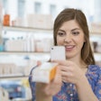 A consumer scans a coded pharmaceutical carton at a pharmacy.