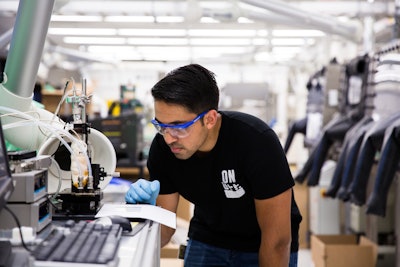 Graduate student research assistant in the Shtein lab, Siddharth Borsadia, prints fluorescein crystals onto a cooled glass plate using organic vapor jet printing. (Photo by Levi Hutmacher, Michigan Engineering.)