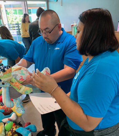 At a RARE Bears event, employees select stuffed bears in unique patterns for children with rare diseases.