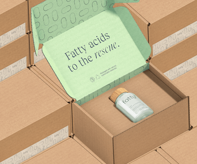 The inside of the corrugated shipper is laminated with a printed top sheet that conveys the upbeat, quippy brand messaging. Stacked shippers illustrate how little space is wasted in this packaging system.