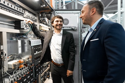 The solution, which is the only one of its kind on the market, allows for VPN connections monitoring, protects the machine network at the customer's site with a firewall and is particularly user-friendly. Left: Dr. Eng. Benjamin Haefner, Group Leader Industrial IT at Optima. Right: Markus Irle, Vice President Firewall & Security at LANCOM Systems (Source: Optima).
