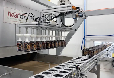 A two-axis gantry robot uses vacuum pickup to pick 20 cans and place them on the infeed belt of an oven that cures the varnish.