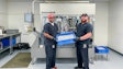 John Lamm, Juana Roll Technician Lead (left), and Elijah Streadwick, Assistant Manager (right), both of NGW, with product in front of the JuanaRoll eight-channel automatic pre-roll machine, available in models with from one to eight channels.