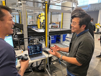 Zenni Director of Distribution and Facilities Simon Goh (right), talks about the deployment now underway with OSARO’s Bryan Yong, a Senior Solutions Engineer at the AI robotics company's San Francisco Robot Lab.
