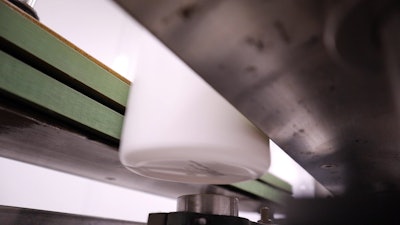 Videojet printer applying ink to a bottle.