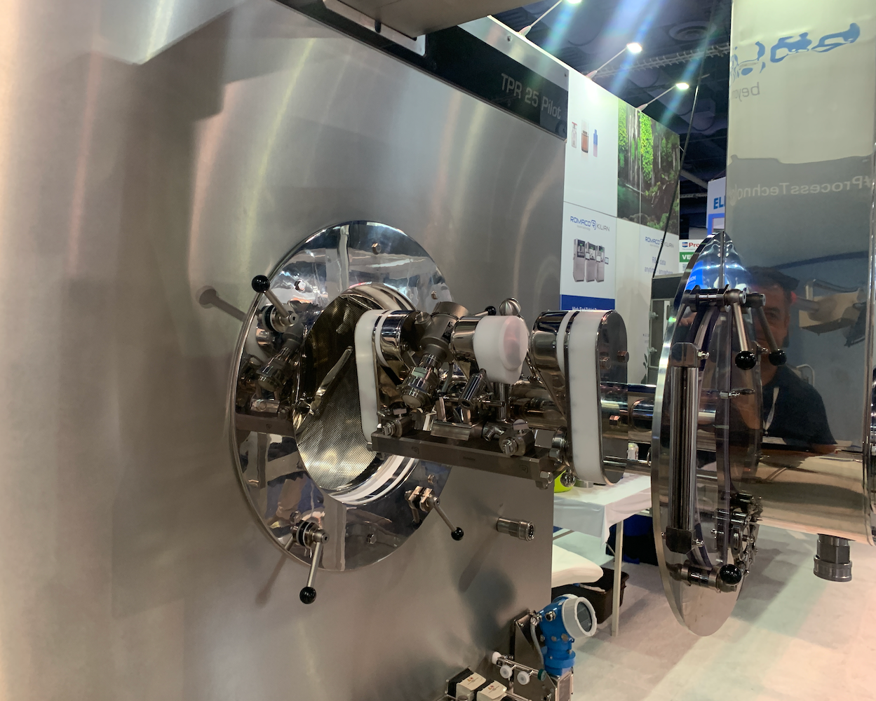 Romaco showcased its new TPR 25 tablet coater at PACK EXPO Las Vegas, with its pictured automated spray arm and nozzles.