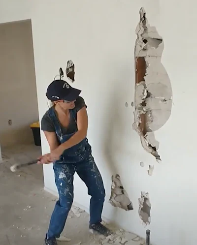 Gessell takes down a wall in her house. That drywall never stood a chance.