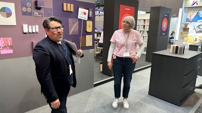 Melichar (left) and Andrea Wecke, Gmund, discuss paper alternatives from sources like grass and hemp.