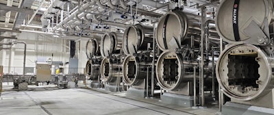 Shown here are five of the 11 full-immersion rotary retorts used on the new can line. Also visible is the shuttle that carries baskets of cans to and from the retorts and the tracks on which the shuttle runs.