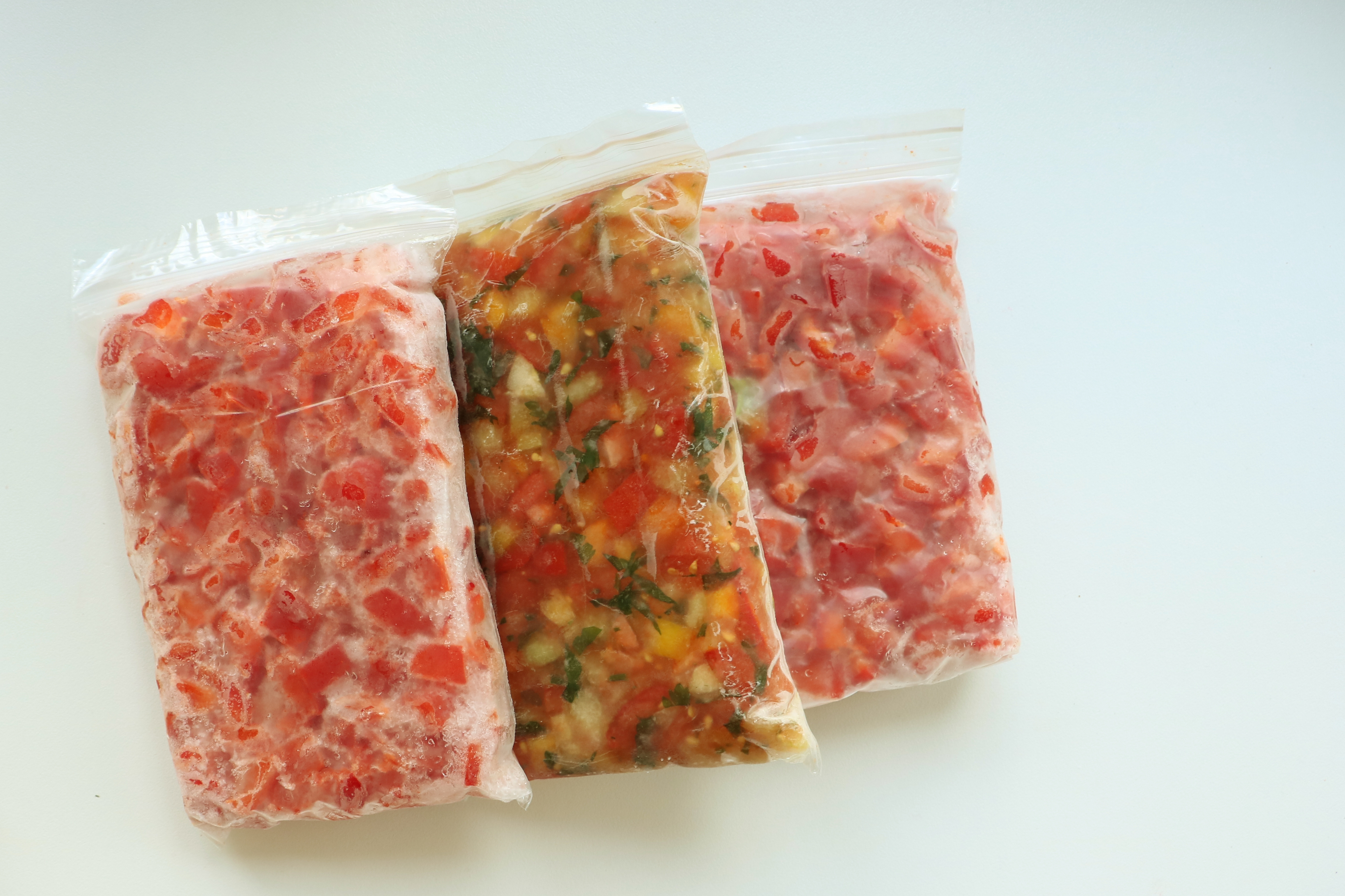 Three vacuum-sealed bags of chopped red and mixed vegetables