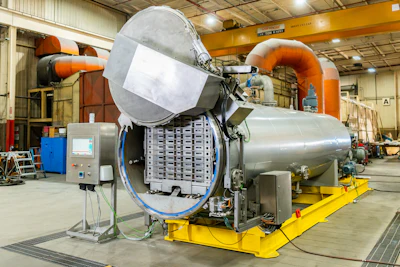 Large industrial autoclave or pressure chamber in manufacturing facility
