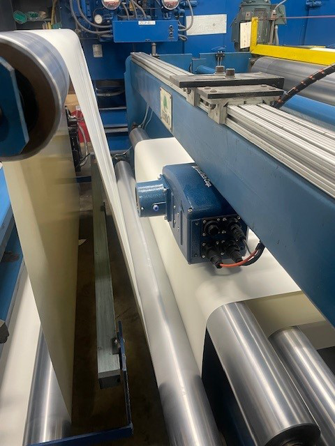 Industrial machinery with blue metal components and large cylindrical rollers