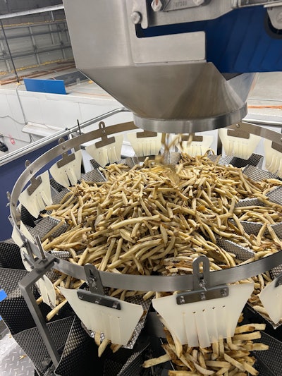 This 14-head combination scale drops 5-lb portions of Frozen French fries into a vertical form/fill/seal system below.