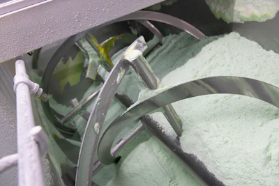 Industrial machinery with curved metal structural components and pale green surfaces