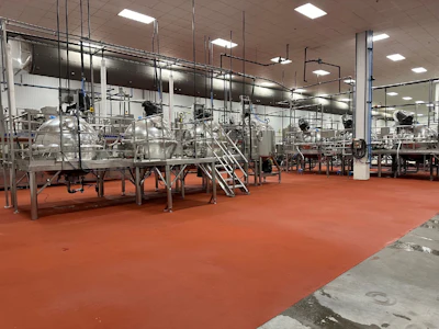 Industrial food processing facility with stainless steel mixing tanks and equipment