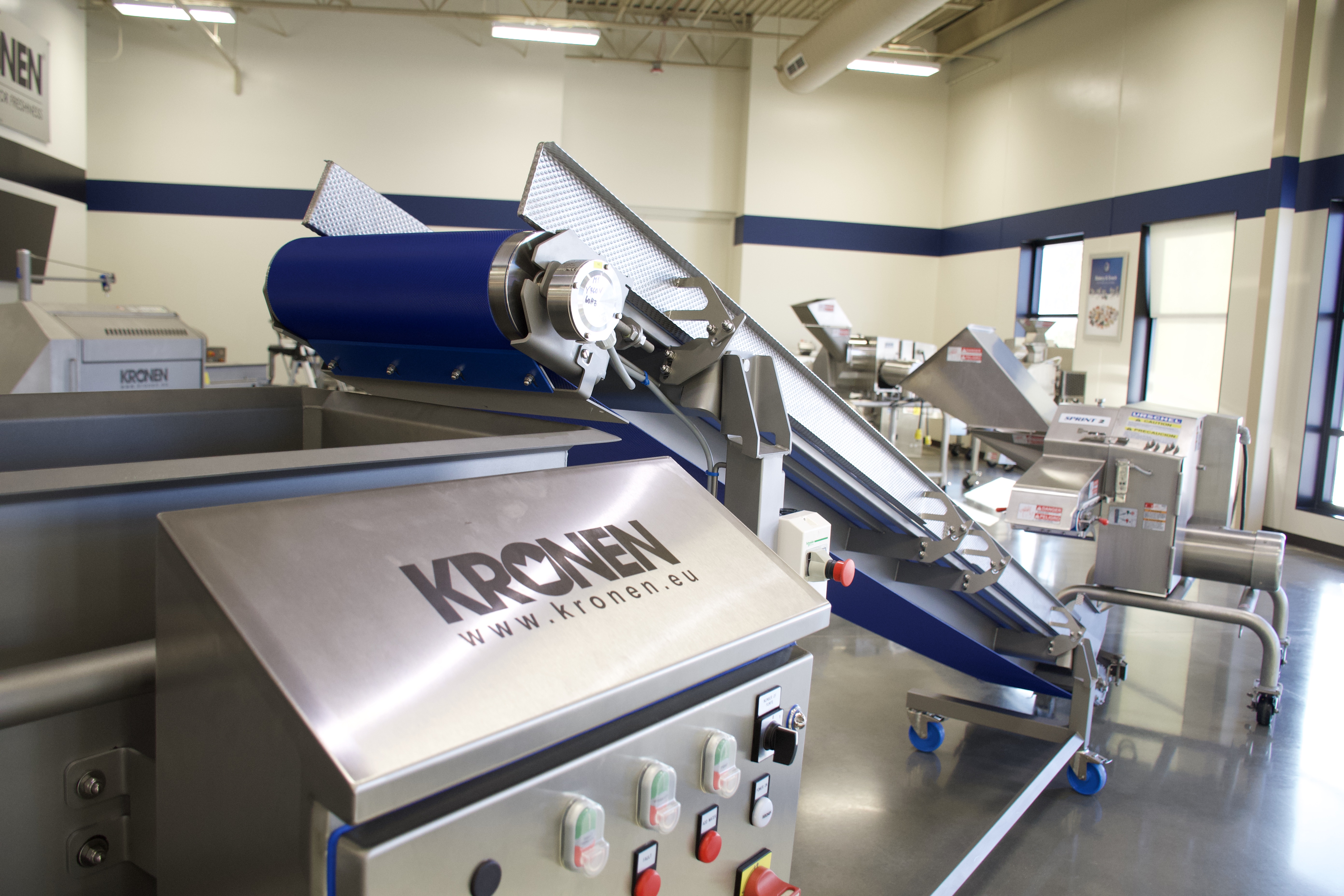 Industrial food processing machine with Kronen branding in commercial kitchen setting