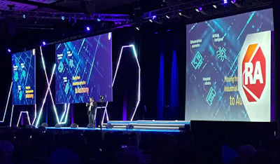 Technology conference stage with RA logo and digital graphics