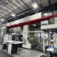Large industrial printing or manufacturing facility with complex machinery and control stations