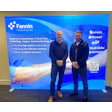 Fannin medical technology display with two professionals at corporate event backdrop