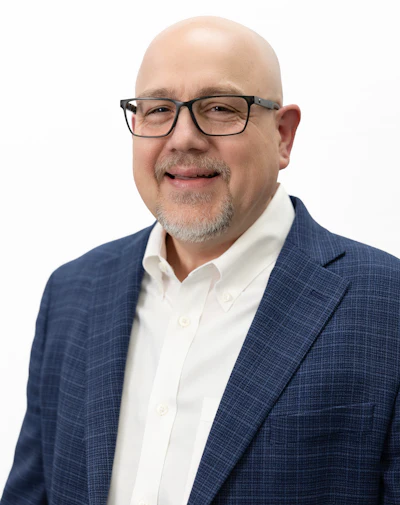 Professional man in blue blazer and white shirt, wearing glasses and smiling