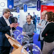 Trade show professionals discussing medical technology near exhibition displays