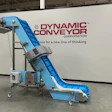 Blue industrial incline conveyor with modular blue ribbed belt in manufacturing facility