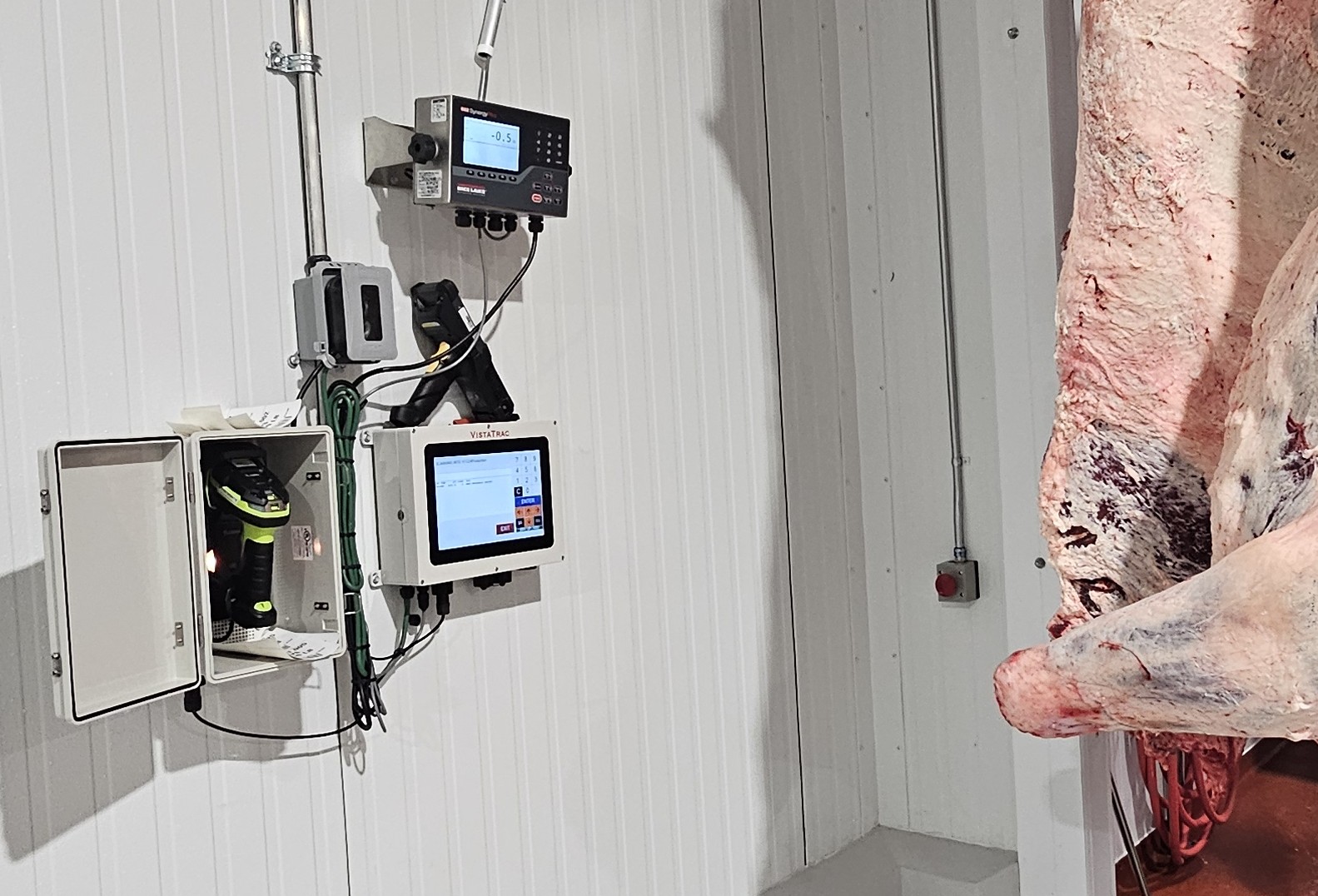 Industrial control system with dual display monitors and electronic equipment mounted on corrugated metal wall