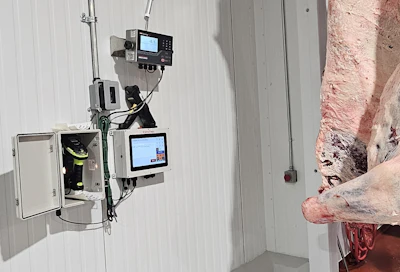 Industrial control system with dual display monitors and electronic equipment mounted on corrugated metal wall