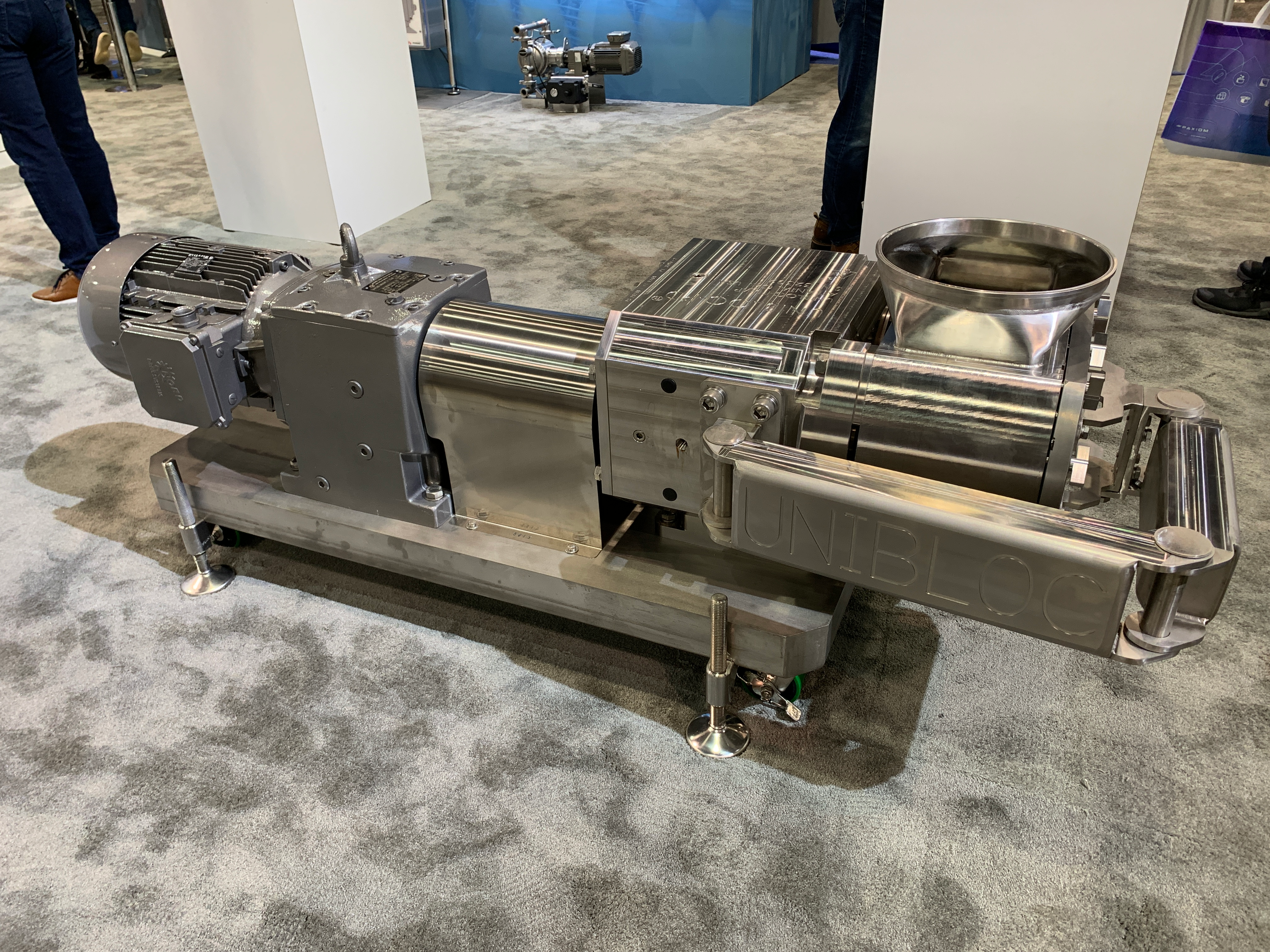 Industrial stainless steel progressive cavity pump with motor assembly displayed at trade show