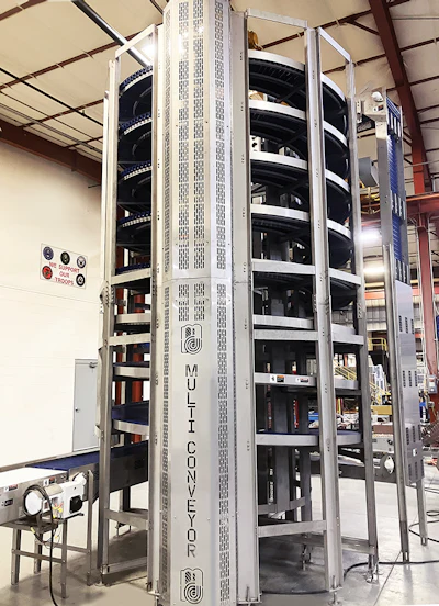 Multi-Conveyor spiral conveyor system installed in industrial warehouse facility with metal framework and internal mechanisms visible
