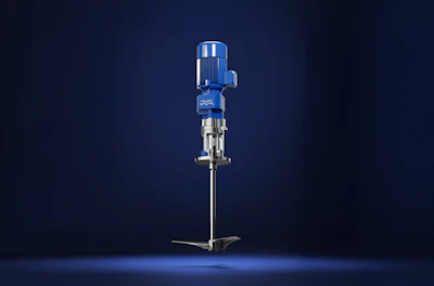 Industrial vertical pump with blue motor housing and metallic shaft assembly on dark background