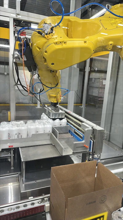 A robotic arm cases bundled pharmaceutical bottles after Antares Vision’s system captures each serial number at line speed, without bottle orientation.