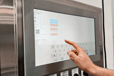 Person using interactive touchscreen display showing bar chart data and on-screen keyboard interface