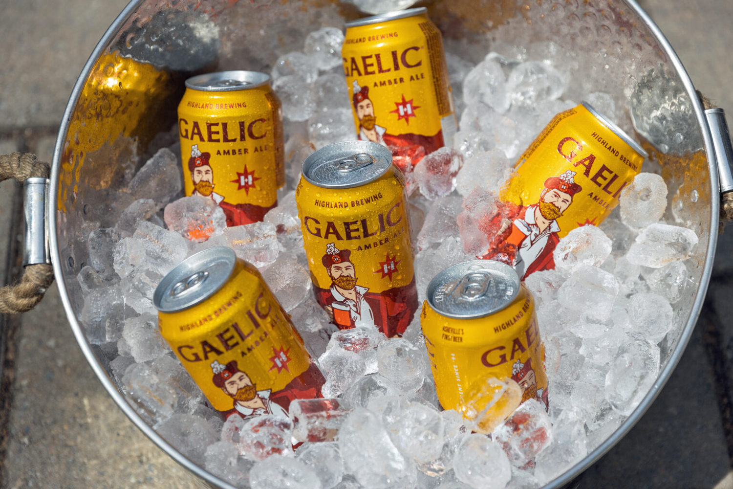 Gaelic Amber Ale beer cans chilled in ice bucket with metal handles