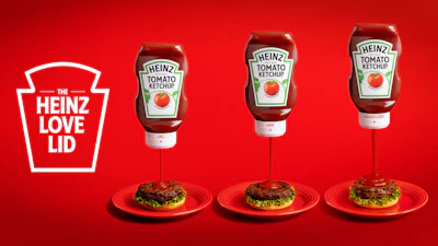 Rotating the Love Lid's dial raises an internal core away from a small inner aperture to widen flow. The two-part closure is molded from standard Heinz polypropylene, so recyclability is maintained.