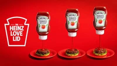 Rotating the Love Lid's dial raises an internal core away from a small inner aperture to widen flow. The two-part closure is molded from standard Heinz polypropylene, so recyclability is maintained.