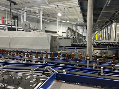 Bottles in the foreground are just about to enter the pasteurizer while the ones in the background have exited the pasteurizer and are on their way to the labeler.