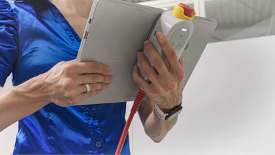 Person in blue shirt holding gray tablet with stylus and red strap