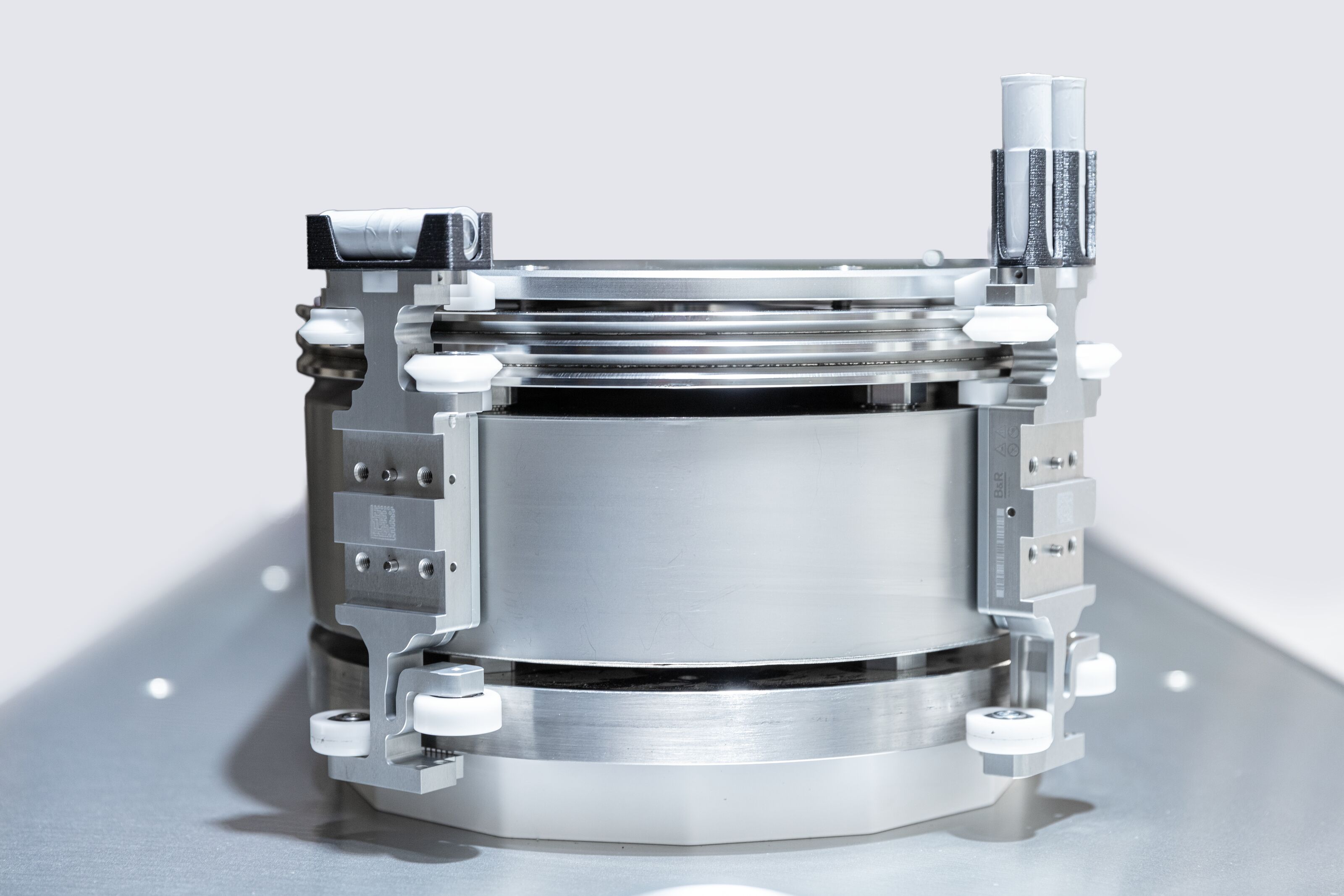 Industrial cylindrical metal device with control panel and transparent reservoir components on neutral background